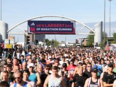 Thousands of runners in the start area of Manchester Marathon, under a banner which reads UK's largest day of marathon running