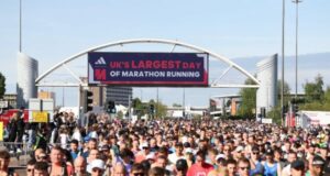 Thousands of runners in the start area of Manchester Marathon, under a banner which reads UK's largest day of marathon running