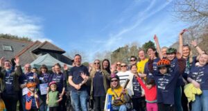 A group of people pose for a photo, all cheering