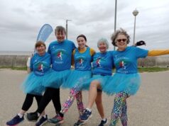 5 ladies dressed in blue T-shirts and tutus do the can-can