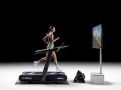 Woman runs on a treadmill with a large screen in front of her