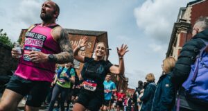 Runners in a race waving at the camera