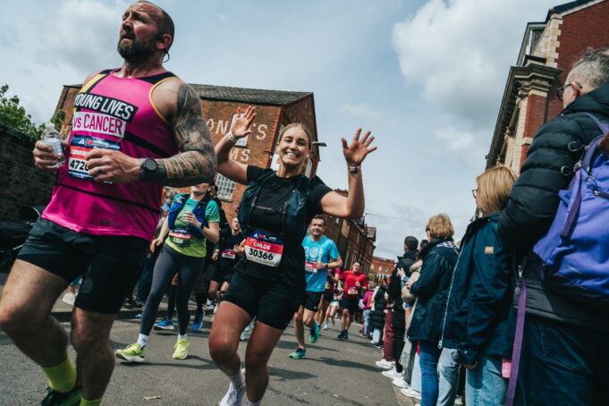 Runners in a race waving at the camera