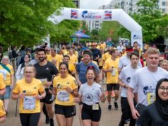 Many runners - a lot wearing yellow tops - take part in a running event