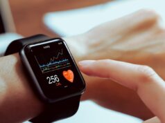 smartwatch on a persons wrist about to be pressed with a finger pointing at the screen
