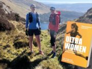Two runners stand on a hillside. An image of their book, Ultra Women, is superimposed onto the bottom right corner of the photo