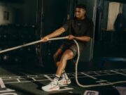 Male athlete pulls on rope in a gym