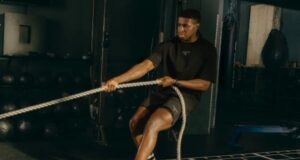 Male athlete pulls on rope in a gym