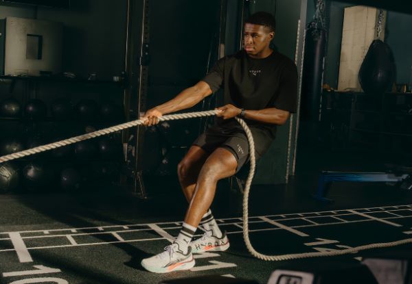 PUMA HYROX AW25 (5) Male athlete pulls on rope in a gym