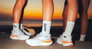 Feet of runners all wearing a white trainer with orange stripe