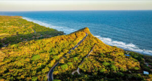 A green mountainous landscape fringed by sea