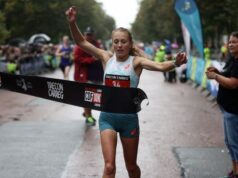Woman runs through finish tape