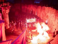 Fire glows inside a castle as hundreds of runners line up pre-dawn to start the race
