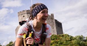 A woman looks thrilled at the finish line - a castle is visible in the background