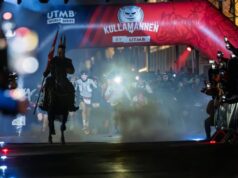 A Viking on a horse leads runners across the start linne. It is night time.