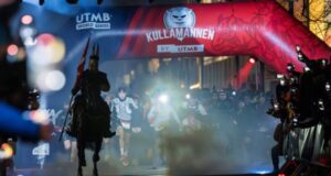 A Viking on a horse leads runners across the start linne. It is night time.