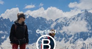 A male an female athlete stand on an alpine mountain top