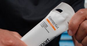 Closeup of hands holding an energy gel in a white packet