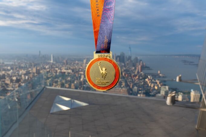 Edge and Vessel NYC marathon A medal on a roof above New York with a view of the city below