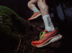 Saucony Peregrine 16: What’s New? Close up of runner's feet in orange shoes stepping over a tree trunk