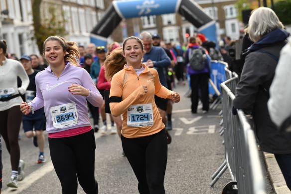 Fulham 10k Two young female runners amid a crowd of runners on a busy street