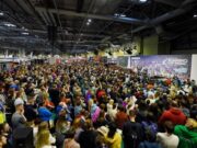 A crowd of people sit in front of the National Running Show stage