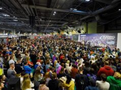 A crowd of people sit in front of the National Running Show stage