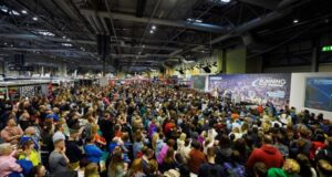 A crowd of people sit in front of the National Running Show stage