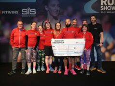 A group of people wearing red tops hold a large cheque