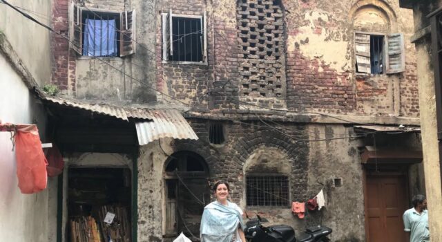 Photo of woman in front of an Indian home