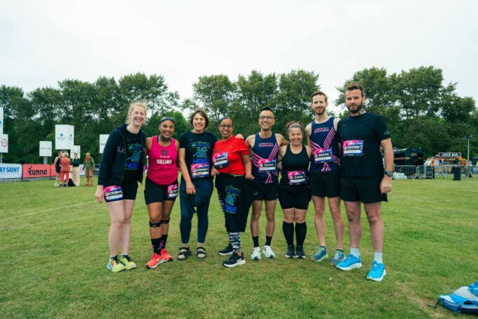 A7408915 A group of 8 male and female runners wearing race numbers pose for a photo
