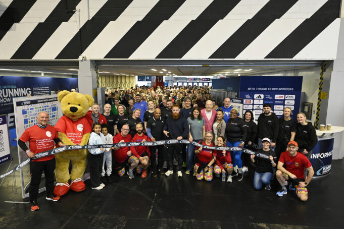A group of people stand at a barrier tape at the entrance to a hall