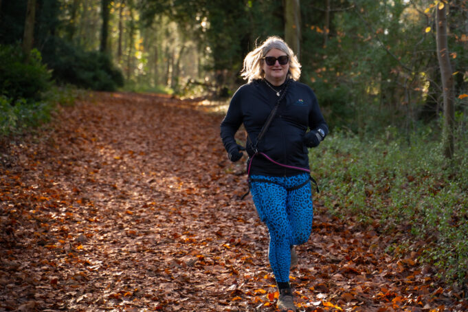Trail and Bloom - Catherine A blonde woman runs through a forest