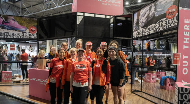 A group of women mostly wearing orange pose at the national running show