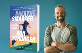 A man on the right of the picture smiles and looks at the camera, his arms folded. On the left is an image of the book Breathe Smarter, Run Stronger