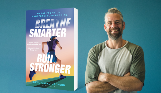 A man on the right of the picture smiles and looks at the camera, his arms folded. On the left is an image of the book Breathe Smarter, Run Stronger
