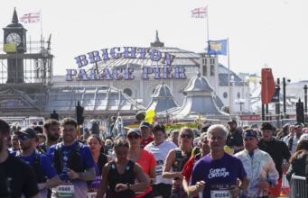 Runners pass the Brighton Palace pier