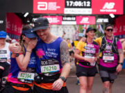 A man and woman hug as they cross the finish finish line