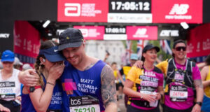 A man and woman hug as they cross the finish finish line