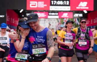 A man and woman hug as they cross the finish finish line
