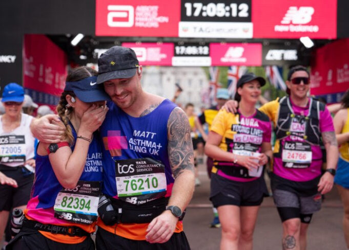A man and woman hug as they cross the finish finish line