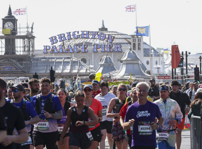 Runners pass the Brighton Palace pier
