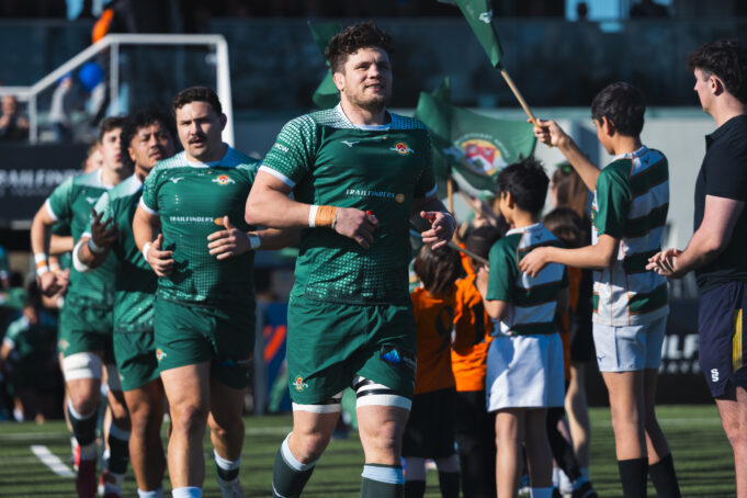 Ealing Rugby Male rugby players in green run out onto a pitch