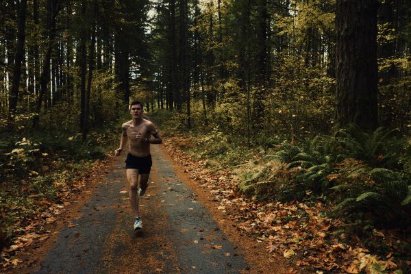 Jakob COROS A topless male runner on a track through a forest