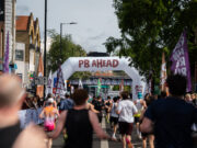 Record turnout at London’s biggest half marathon Runners on a London street. A gantry over the road reads PB Ahead