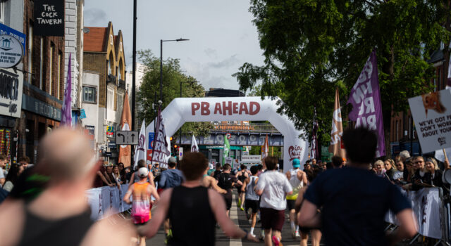 Record turnout at London’s biggest half marathon Runners on a London street. A gantry over the road reads PB Ahead