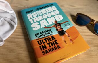 Running Through Sand: we can still do hard things Book and sunglasses on a wooden table