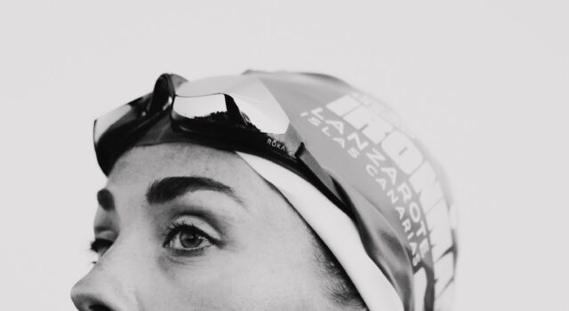 Lucy Charles-Barclay returns 16 weeks after surgery Black and whiite image of a head and shoulders shot of woman in a wetsuit with goggles and swimcap on head