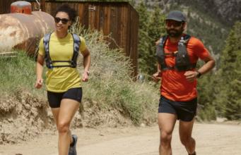 Artilect Sprint Tee Review A male and female runner each wear a red and yellow t-shirt respectively, black shorts and a race vest.