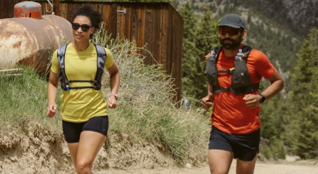 Artilect Sprint Tee Review A male and female runner each wear a red and yellow t-shirt respectively, black shorts and a race vest.